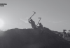 Silhouetted workers laboring at sundown in a rural Indian field